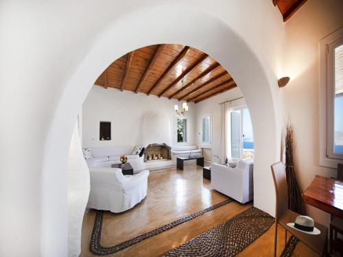 a living room with white furniture and an archway at Villa in Mykonos near Agios Sostis Beach in Agios Sostis Mykonos
