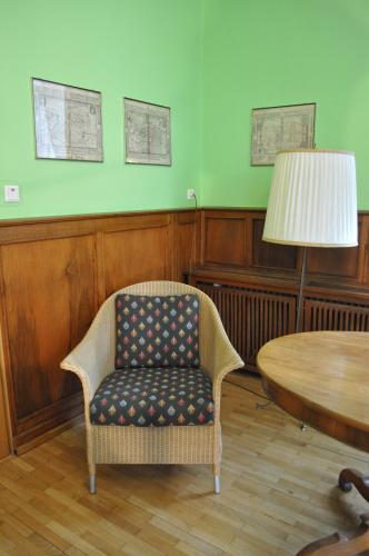 a room with a chair and a table with a lamp at Hotel Cramer Bed & Breakfast in Werlte