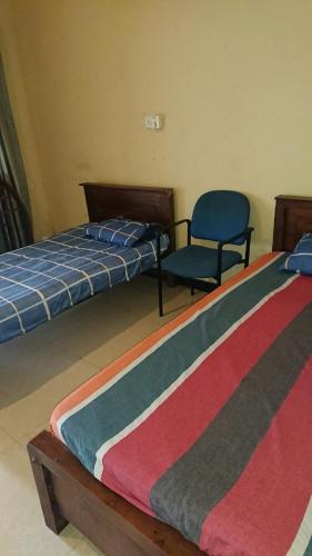 a room with two beds and a chair in it at LEAF resorts in Gampola