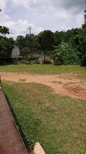 a field of grass with a dirt road at LEAF resorts in Gampola