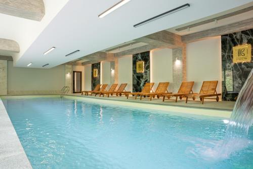 a swimming pool with chairs and a fountain at Kutaisi Inn in Kutaisi