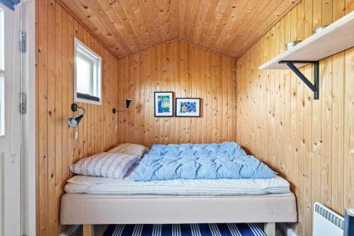 a bed in a room with a wooden wall at TV1426-Skagen-Sostjernevej-1-B in Skagen