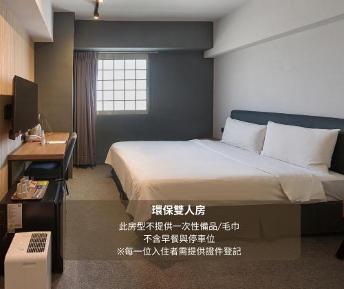 a bedroom with a bed and a desk and a window at Doudian DDiNN Hotel in Taichung
