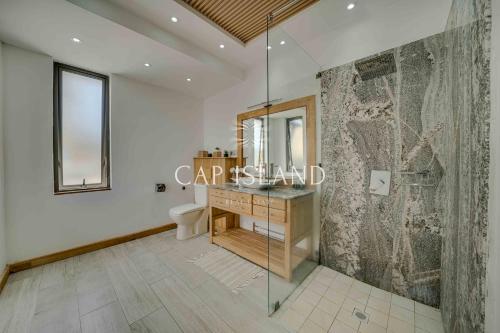 Un baño con lavabo, inodoro y espejo. en Elegant Villa Emeraude, splendid pool, en Grand Baie