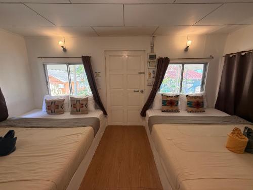 two beds in a room with two windows at Apache Loongdum Koh Samed in Ko Samed