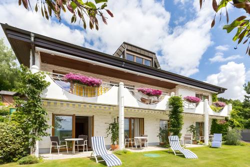 a house with chairs and flowers in the yard at Gästehaus Anita in Gailingen