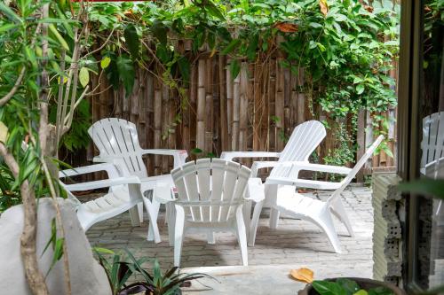 a group of white chairs sitting in front of a fence at Seetanu Bungalows in Srithanu