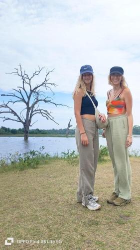 two women standing next to a body of water at Udawalawa Safari House in Udawalawe