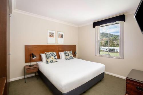 a bedroom with a large bed and a window at Mantra Lorne in Lorne