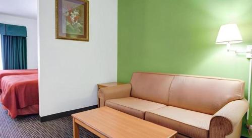 a living room with a couch and a bed at Quality Inn & Suites Airport in Austin