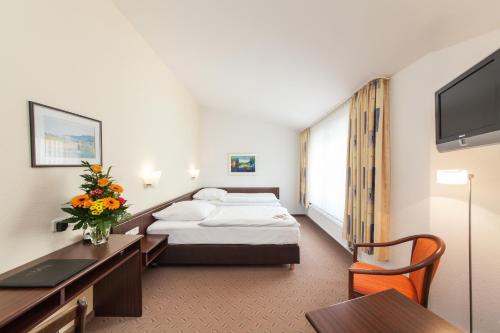 um quarto de hotel com uma cama e uma secretária em Novum Hotel Strijewski em Wolfsburg