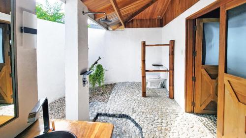 圣胡安Kawayan Holiday Resort的带马桶和木门的浴室