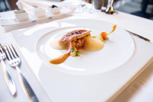 a white plate with food on a table at Hotel Villa Medici in Bad Schonborn
