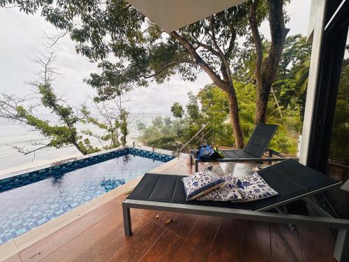 a laptop sitting on a table next to a pool at The French Villa-Santander Cebu in Santander