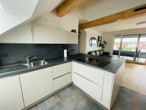 a kitchen with white cabinets and a sink at Urlaub im fränkischen Seenland in Allersberg