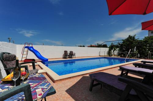 uma piscina com escorrega ao lado em Apartments Villa Velin em Primošten