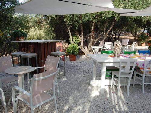 a group of tables and chairs under an umbrella at Villa in Sisi near Beach & Olive Groves in Milatos