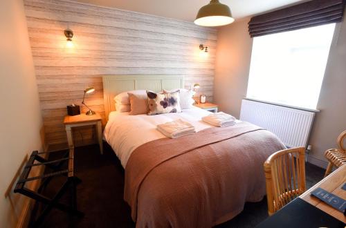 a bedroom with a large bed with a wooden wall at The Lifeboat Inn in Hunstanton