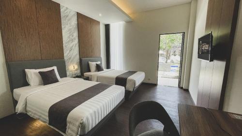 una habitación de hotel con dos camas y una mesa en LPP Garden Hotel, en Yogyakarta