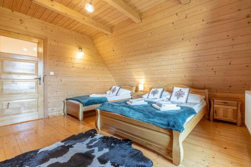 a bedroom with two beds in a log cabin at Osada Szaflary in Szaflary