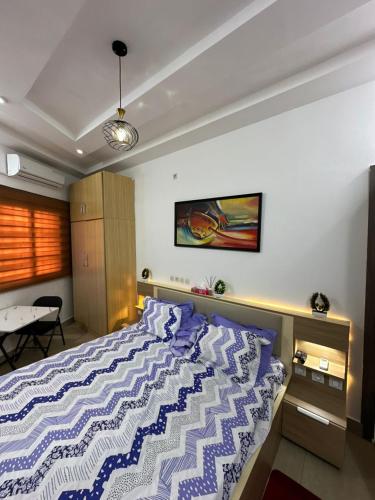a bedroom with a bed with a blue and white comforter at Cristal in Adido Gomé