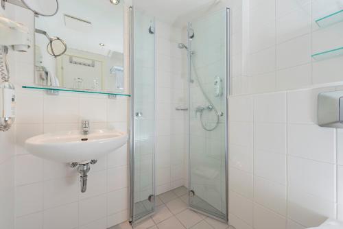 a bathroom with a sink and a shower at AHORN Waldhotel Altenberg in Kurort Altenberg