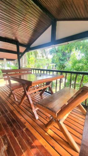 a wooden picnic table sitting on a wooden deck at Floral House in Lamai