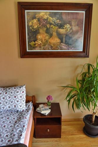 a bedroom with a painting on the wall and a table with a plant at Jovanovic Guest House in Ohrid