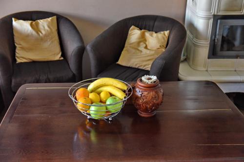 a bowl of fruit on a table with two chairs at Jovanovic Guest House in Ohrid