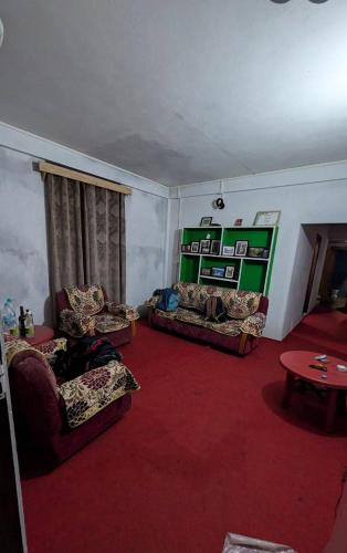 a living room with two couches and a red carpet at Sunset inlet homestay Cherrapunjee in Shillong