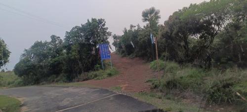 a road with a blue sign on the side of it at Sunset inlet homestay Cherrapunjee in Shillong