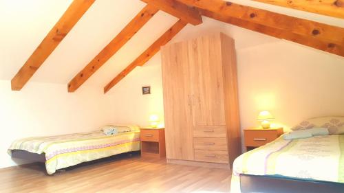 a attic room with two beds and a wooden ceiling at Apartment Nevenka in Medulin