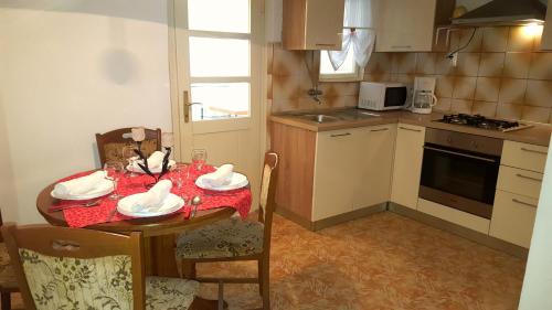 a small kitchen with a table with a red table cloth at Apartment Nevenka in Medulin