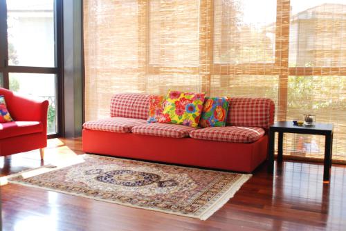 a red couch sitting in a living room with a rug at Beija-Flor b&b in Verano Brianza