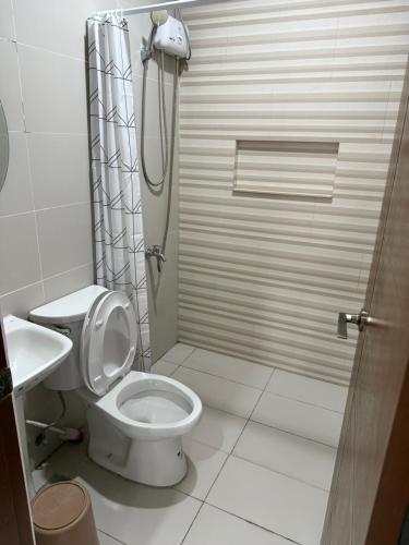 a bathroom with a shower and a toilet and a sink at Lheaf Residences and Serviced Apartments in Cebu City