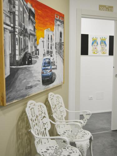 a room with white chairs and a painting on the wall at Abraxia Guest House in Comiso