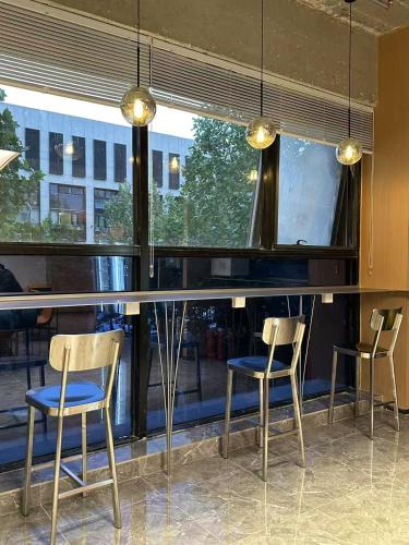 un bar con tre sedie davanti a una finestra di wohkoon Youth Hostel Beijing Fengtai Railway Station Branch a Pechino