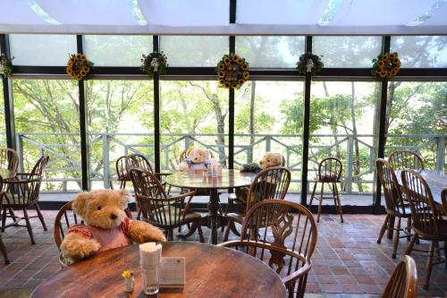 two teddy bears sitting at tables in a restaurant at YU-FURI Nasu-Takao Onsen Lodge in Nasu