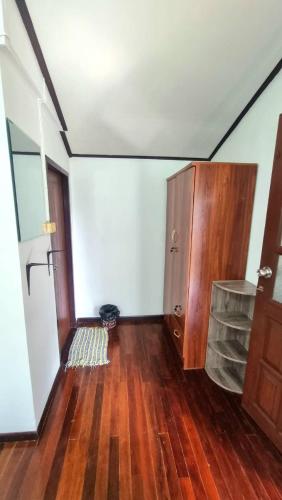 an empty room with a wooden floor and a cabinet at Floral House in Lamai