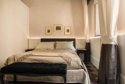 a bedroom with a large bed with a black ottoman at La Terrazza Sul Campo-Rooms Only in Siena