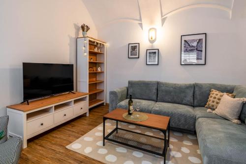 a living room with a couch and a flat screen tv at Apartmány U Purkmistra - Ve Dvoře in Polička