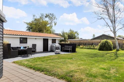 a patio with a table and chairs in a yard at TV1518-Albaek-Sdr-Havnevej-20 in Ålbæk
