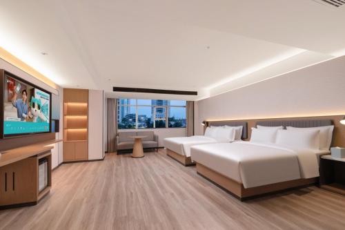 Postel nebo postele na pokoji v ubytování Echarm Hotel Haikou Friendship Sunshine City Wanlvyuan Branch