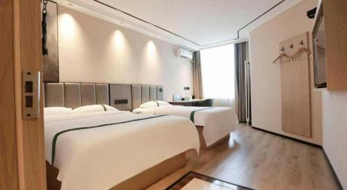 a hotel room with two beds and a window at GreenTree Inn Langfang Sanhe South Yingbin Road Express Hotel in Sanhe