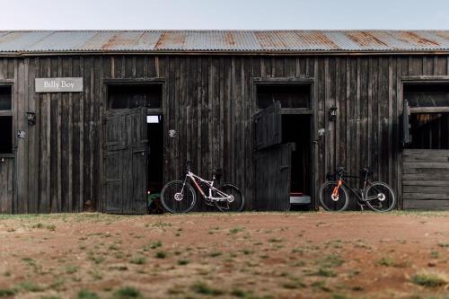 due biciclette parcheggiate davanti a un edificio in legno di Dwarsvlei Venue - Camping & Stables a Middelburg