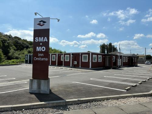 a parking lot with a sign in front of a motel at SMA MO inn Omitama in Omitama