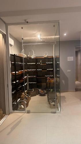 a glass display case filled with lots of wine bottles at Golden Coast Suites in Kipseli