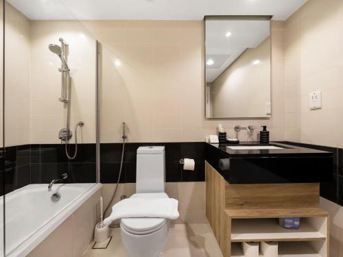 a bathroom with a tub and a toilet and a sink at Luxury Stay in Downtown-Steps to Burj & Dubai Mall in Dubai