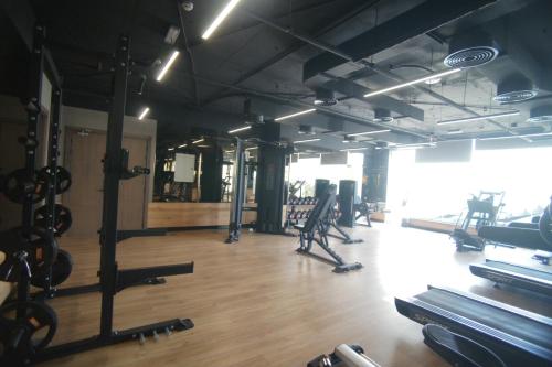 a gym with a lot of exercise equipment in a room at Liaqat Airport Residence Al Mouj in Mawāliḩ
