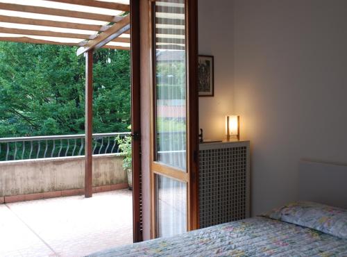 sypialnia z łóżkiem i przesuwanymi drzwiami szklanymi w obiekcie Beija-Flor b&b w mieście Verano Brianza
